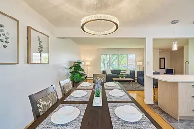 a dining room and living room with a table and chairs at Chinook Executive Entire House in Calgary