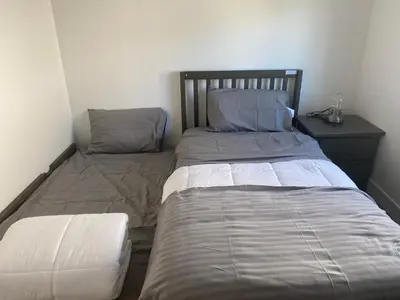 a bedroom with two beds and a night stand at Lakeside Cottage in Nanaimo