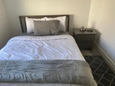 a bedroom with a bed and a night stand at Lakeside Cottage in Nanaimo