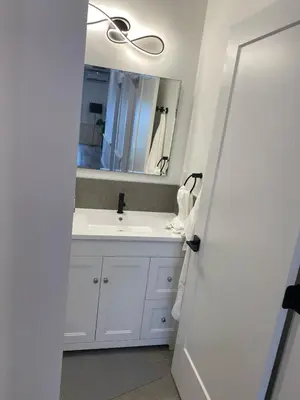 a bathroom with a white sink and a mirror at Lakeside Cottage in Nanaimo