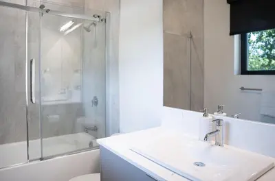 a white bathroom with a sink and a shower at Rustic Retreat by Revelstoke Vacations in Revelstoke