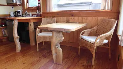 a wooden table and chairs in a kitchen with a window at Seine Boat Inn in Alert Bay