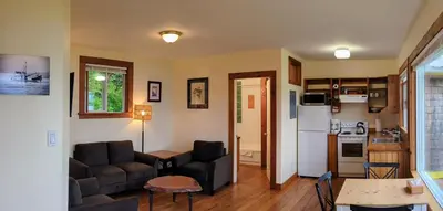a living room with a couch and a kitchen at Seine Boat Inn in Alert Bay