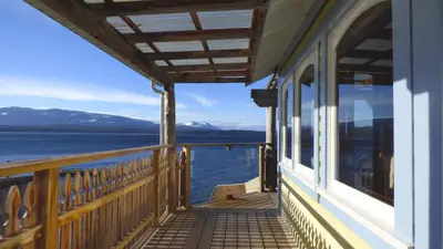 a balcony of a house with a view of the water at Seine Boat Inn in Alert Bay
