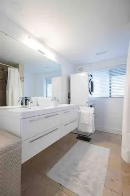 a white bathroom with a sink and a mirror at OCEAN FRONT 2 BEDROOM SUITE with STUNNING VIEWS in Victoria