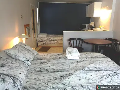 a bedroom with a large bed and a kitchen at WhiteTail Suite - Misty River Lodge - in Radium Hot Springs