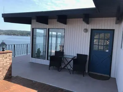 a house with a blue door and a table and chairs at Ocean Front Retreat with Stunning Water Views in Victoria