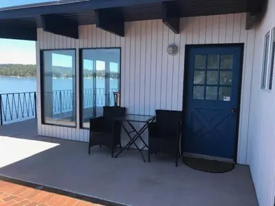a house with a blue door and a table and chairs at Ocean Front Retreat with Stunning Water Views in Victoria