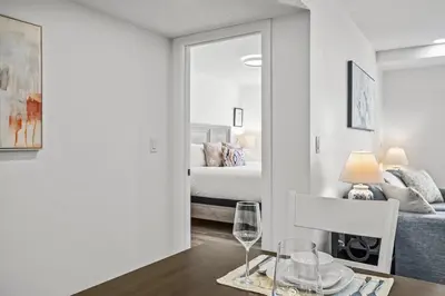a bedroom with a bed and a table with a wine glass at T202 BRAND NEW! The Mountain's Call- Mountain View Stay in Canmore