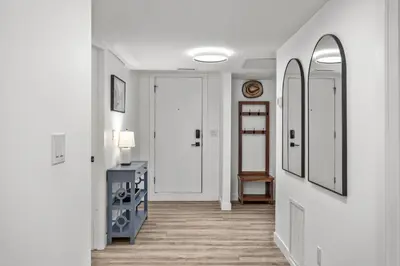 a hallway with white walls and wooden floors and a door at T202 BRAND NEW! The Mountain's Call- Mountain View Stay in Canmore
