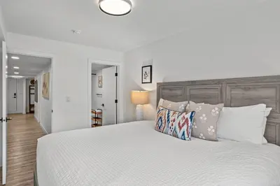 a white bedroom with a large bed with pillows at T202 BRAND NEW! The Mountain's Call- Mountain View Stay in Canmore