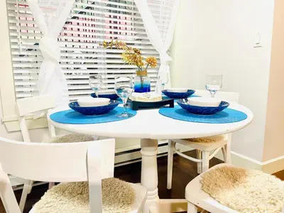 a white dining room with a white table and chairs at Langley Heights 2 Bedrooms Sweet Suite in Langley