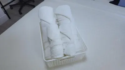 a basket of towels sitting on a bed at Cozy Retreat in Mission City
