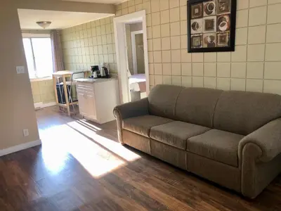 a living room with a couch and a kitchen at Canterbury Inn in Invermere
