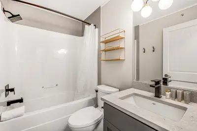 a white bathroom with a toilet and a sink at Vista at Big White w Amazing Location and View in Big White
