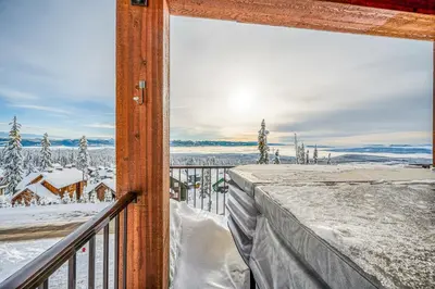 a balcony with a view of a snow covered yard at Vista at Big White w Amazing Location and View in Big White