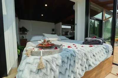 a bedroom with a large bed with flowers on it at Refuge Bay Caelum Cabin Luxury Off Grid Escape in Cherhill
