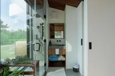 a bathroom with a shower and a glass door at Refuge Bay Caelum Cabin Luxury Off Grid Escape in Cherhill