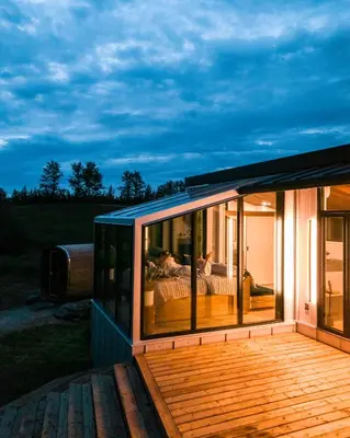 a glass house with a bed on a deck at Refuge Bay Caelum Cabin Luxury Off Grid Escape in Cherhill