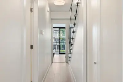 a hallway with white walls and a stair case at Ocean View Townhouse #27 in Oyster Bay