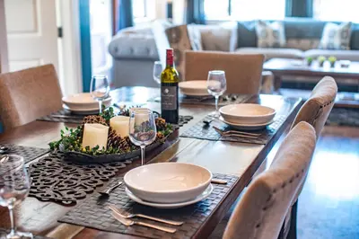 a wooden table with plates and wine glasses on it at Downunder Mountain Retreat in Revelstoke