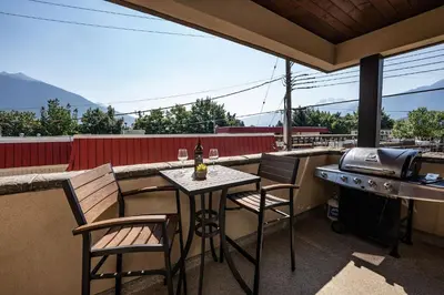 a patio with a table and chairs and a grill at Downunder Mountain Retreat in Revelstoke