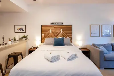 a bedroom with a large bed with two towels on it at Glacier Lodge Premiere Suite in Whistler