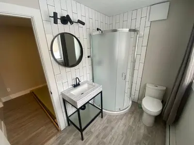 a bathroom with a sink and a toilet and a mirror at Newly Renovated 1br1ba With Asian Style Tea Room in Edmonton