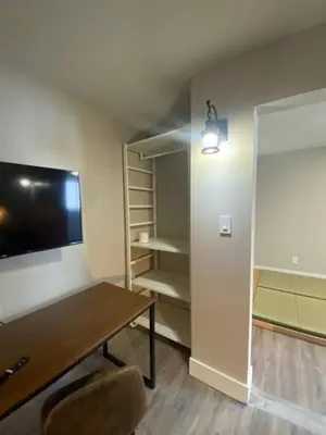 a living room with a table and a tv and shelves at Newly Renovated 1br1ba With Asian Style Tea Room in Edmonton