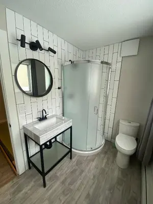 a bathroom with a sink and a mirror and a toilet at Newly Renovated 1br1ba With Asian Style Tea Room in Edmonton