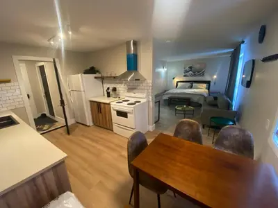 a room with a kitchen and a living room with a table at Newly Renovated 1br1ba With Asian Style Tea Room in Edmonton