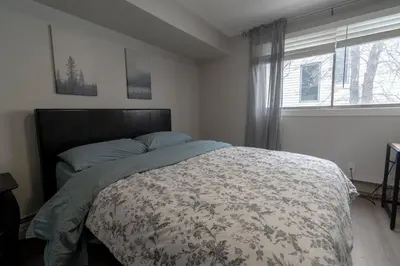 a bedroom with a bed and a window at Guest Suite Close To Whtye Ave in Edmonton