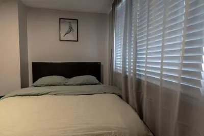 a bedroom with a bed and a window with blinds at Guest Suite Close To Whtye Ave in Edmonton
