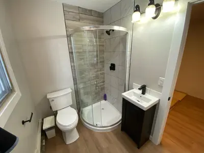 a bathroom with a shower and a toilet and a sink at Close To Whyte University New Renovation in Edmonton