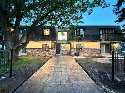 a brick building with a tree in front of it at Close To Whyte University New Renovation in Edmonton
