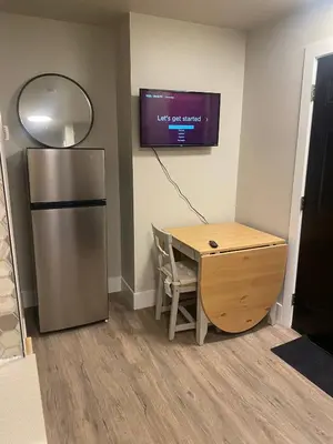 a kitchen with a desk and a refrigerator and a tv at Brand New Modern Flat 2br1ba Whyte And University in Edmonton