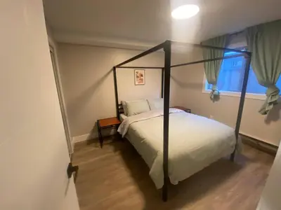 a bedroom with a canopy bed and a window at Brand New Modern Flat 2br1ba Whyte And University in Edmonton