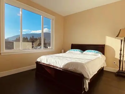 a bedroom with a bed and a large window at \u6d77\u5c9b\u6c11\u5bbf 3\u5f20\u5e8a-2\u95f4\u5367\u5ba4\u72ec\u7acb\u5957\u623f in Nanaimo