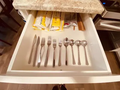 a refrigerator with utensils on a white tray at \u6d77\u5c9b\u6c11\u5bbf 3\u5f20\u5e8a-2\u95f4\u5367\u5ba4\u72ec\u7acb\u5957\u623f in Nanaimo