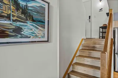 a staircase with a painting on the wall at Freshly Remodeled - 2 King Beds- Breathtaking Views in Canmore