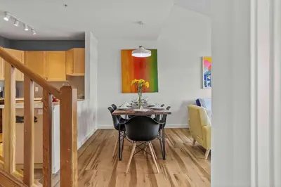 a dining room table with a vase of flowers on it at Freshly Remodeled - 2 King Beds- Breathtaking Views in Canmore