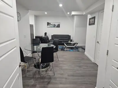 a living room with a glass table and chairs at New 2 bdrm basement suite Seton in Calgary