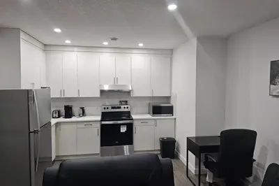 a kitchen with white cabinets and a stove top oven at New 2 bdrm basement suite Seton in Calgary