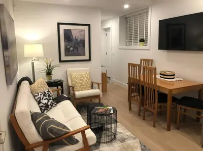 a living room with a couch and a dining room at Modern luxury and convenience in Marda Loop in Calgary