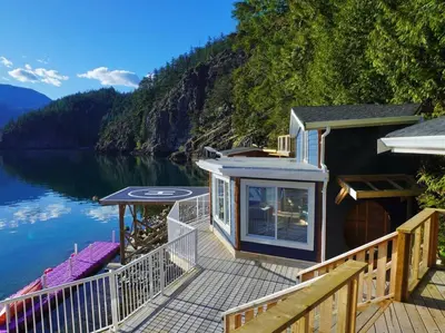 a house on a dock on a body of water at Private Ozarks Island Retreat in Agassiz