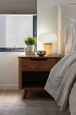 a nightstand with a plant on it next to a bed at Casa Bramble Luxury 2Bed Suite near UofA Hospital in Edmonton