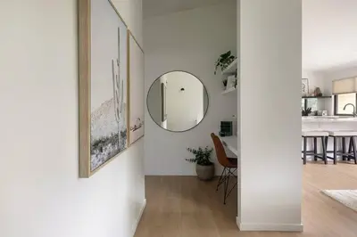 a white hallway with a mirror and a dining room at Casa Bramble Luxury 2Bed Suite near UofA Hospital in Edmonton