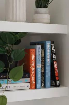 a group of books sitting on a shelf at Casa Bramble Luxury 2Bed Suite near UofA Hospital in Edmonton