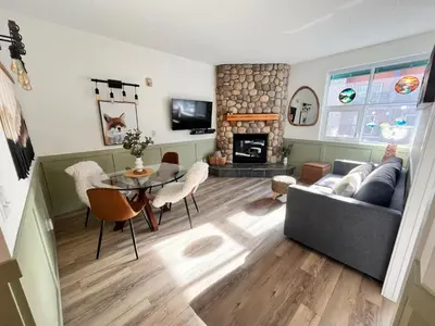 a living room with a table and a fireplace at Three Peaks Getaway Jacuzzi Suite - sleeps 4 in Canmore