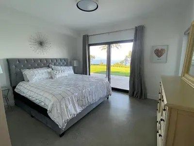 a bedroom with a bed and a large sliding glass door at Winchelsea Views in Nanaimo